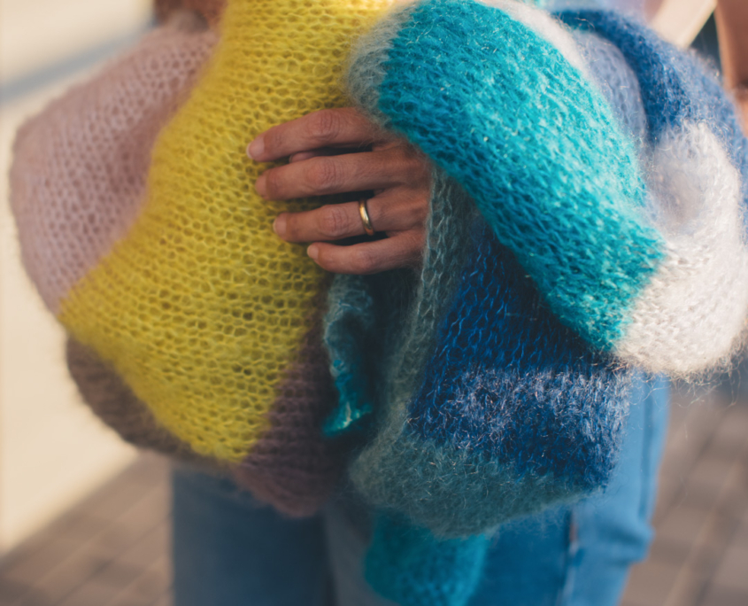 Capo lavorato a maglia in mohair leggero e soffice, con texture traforata e colori sfumati che valorizzano la morbidezza del filato.