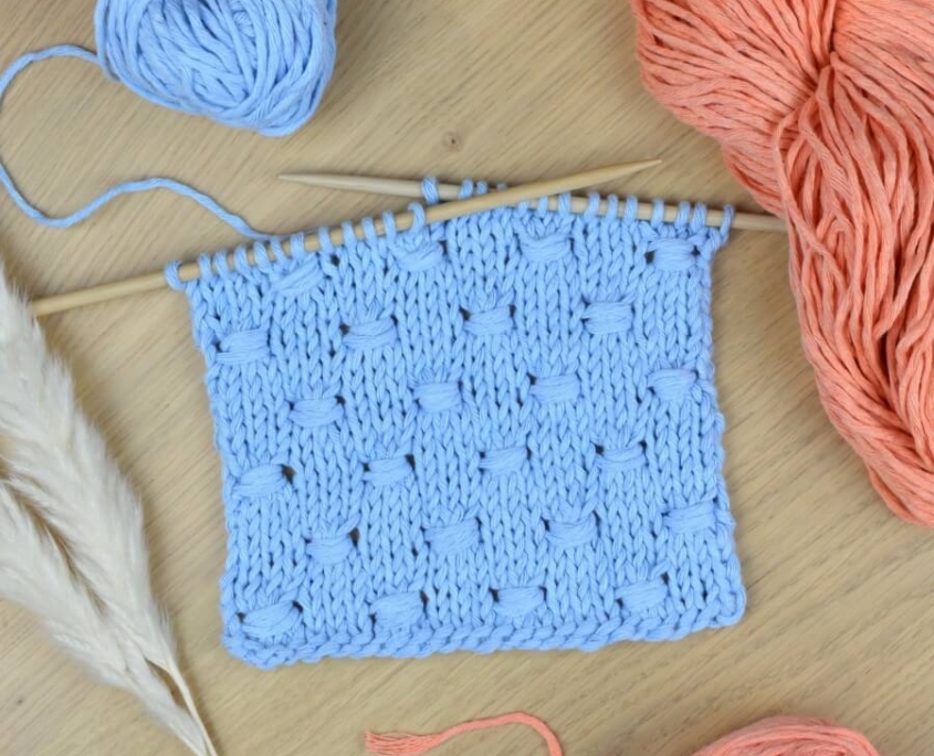 The Estonian Button Stitch is very easy to knit: the foundation stitch is the Stocking Stitch, a knitting staple. The little buttons are made by wrapping the working yarn around groups of three stitches. By following this pattern, the little knots will alternate on diagonal lines.
