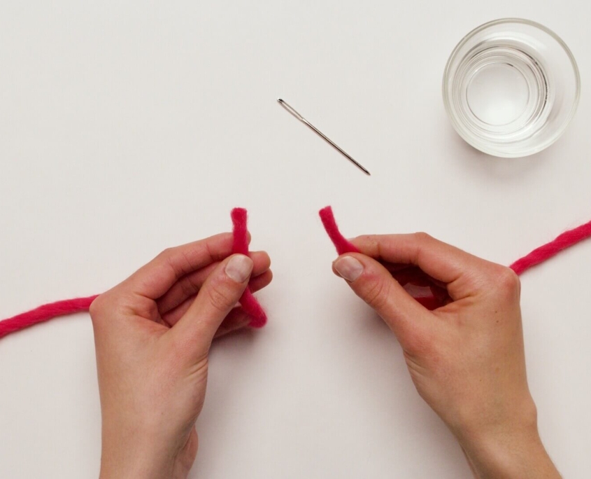 The tails of the two yarn balls to be joined