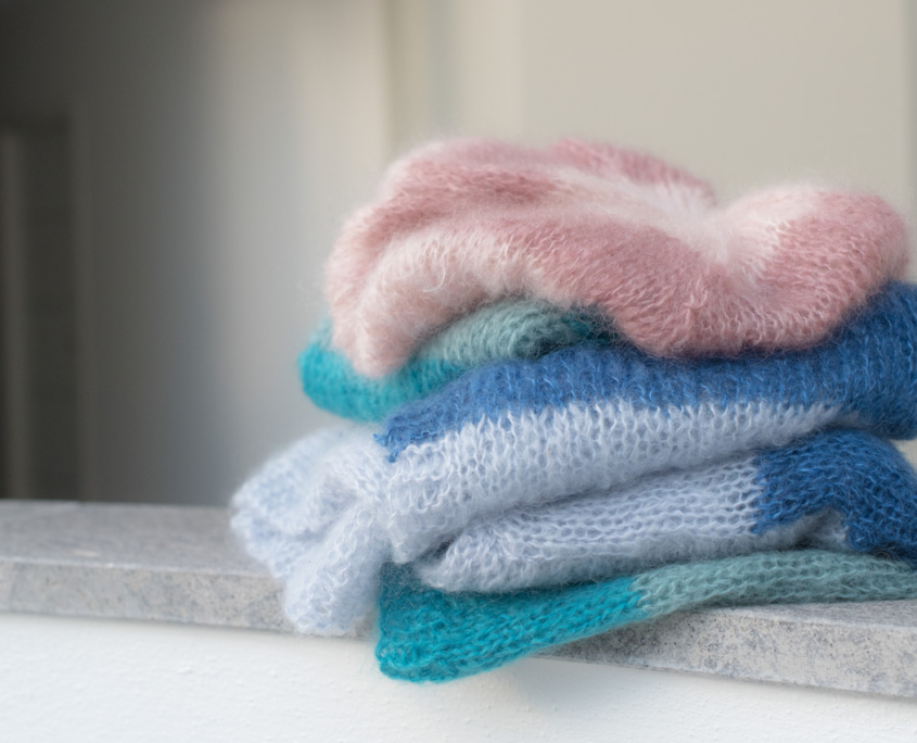 Capi fatti a mano in mohair leggero e soffice, con lavorazione ariosa che evidenzia volume e morbidezza del filato.