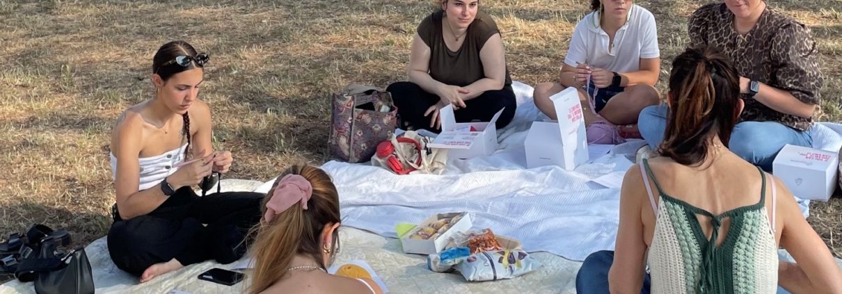 Persone che si dedicano all'uncinetto all'aperto durante un momento di creatività e relax.