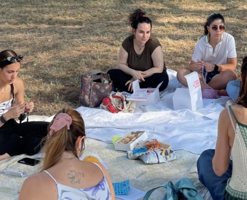 Persone che si dedicano all'uncinetto all'aperto durante un momento di creatività e relax.